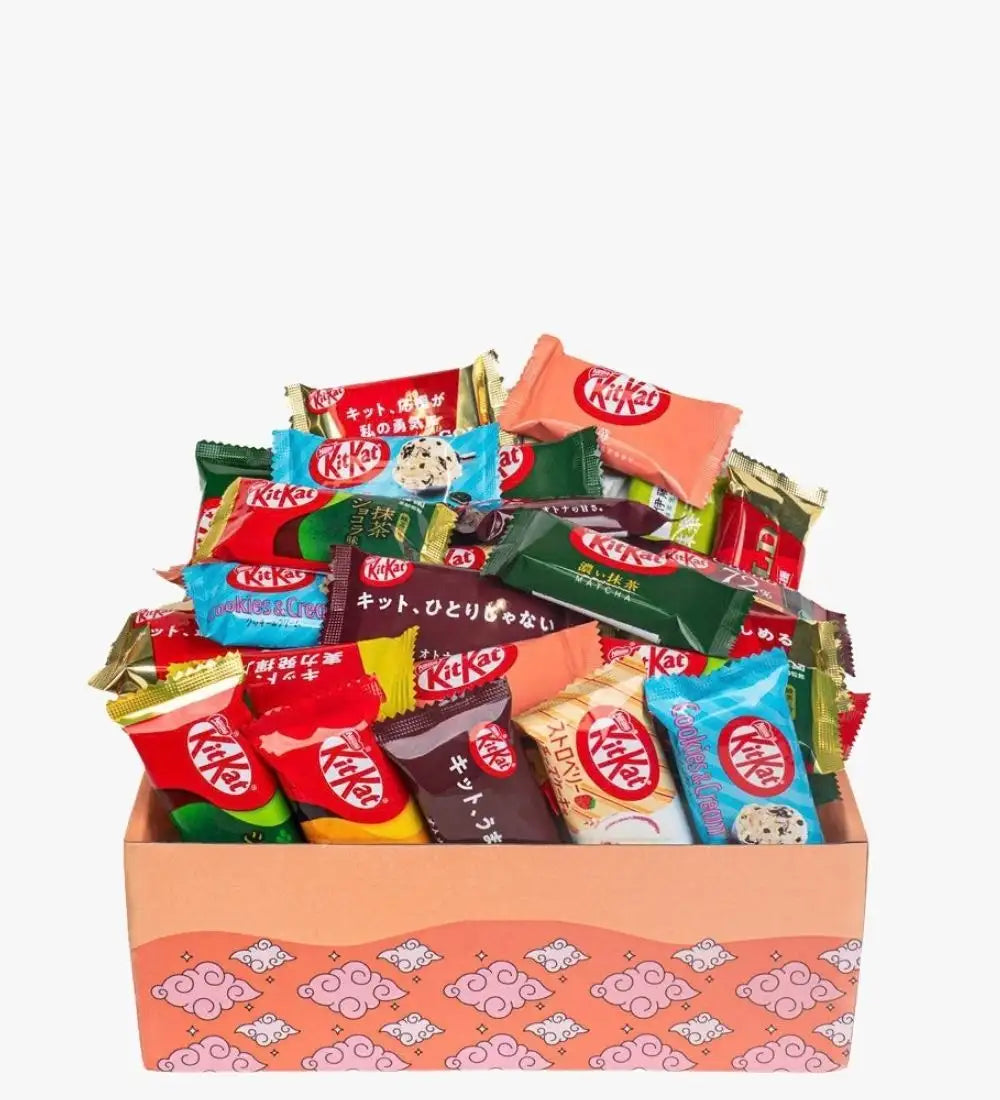 Eine lebendige Auswahl an KitKat-Schokoladenriegeln in verschiedenen Sorten und bunten Verpackungen, eingebettet in eine pinkfarbene Geschenkbox mit Muster.