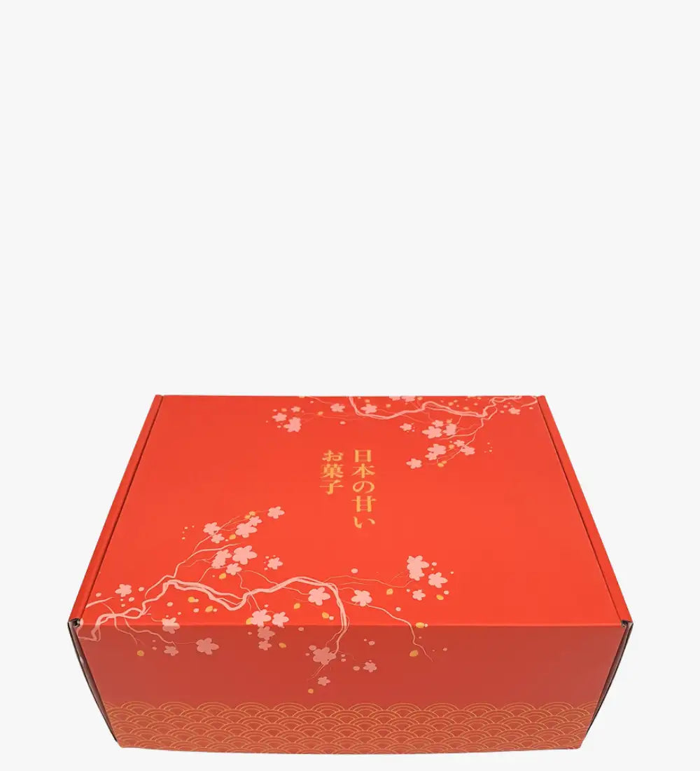 Rote Papp-Geschenkschachtel mit zarten weißen Kirschblüten- und Goldblattmustern, mit japanischem Text entlang der Seite.
